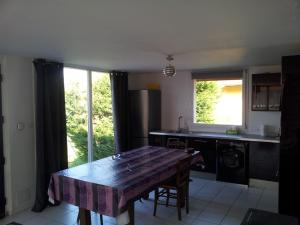 a kitchen with a wooden table in the middle at Le gite@perché in Sainte-Marguerite