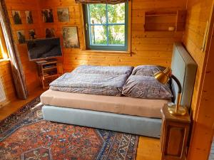 a bedroom with a bed with a lamp and a rug at Malerisches Holzhaus "Coco" mit Kamin, Sauna und eigenem Garten in Kleinfischlingen