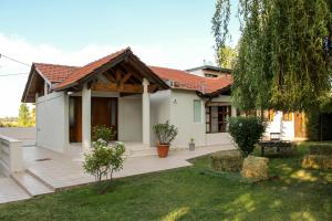 a house with a wooden deck in the yard at De Los Andes Hotel Boutique in Ciudad Lujan de Cuyo