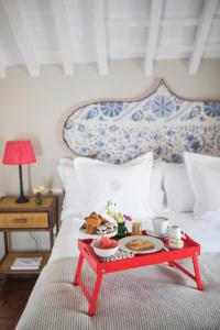 bandeja roja de comida en una cama con desayuno en Posada La Sacristía, en Tarifa
