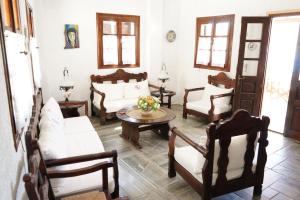 un soggiorno con mobili bianchi e tavolo di Alexandros Hotel a Grikos