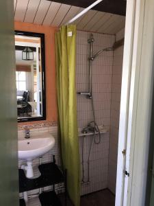 uma casa de banho com um lavatório e um chuveiro com uma cortina de chuveiro em Casita Blanca em El Perelló