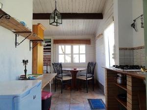 uma cozinha com mesa e cadeiras num quarto em Casita Blanca em El Perelló
