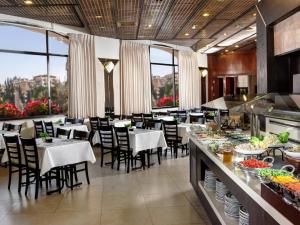 a restaurant with tables and chairs and a buffet at Lev yerushalayim - suites hotel in Jerusalem
