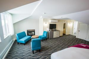 een hotelkamer met twee blauwe stoelen en een tafel bij Mountain Inn at Killington in Killington