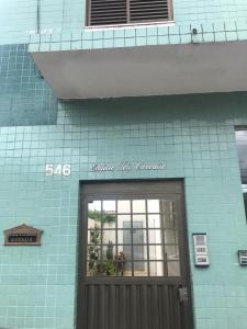 budynek z niebieskiej cegły z drzwiami z przodu w obiekcie Apartamento Centro Lavras w mieście Lavras