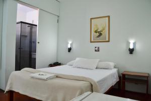 a bedroom with two beds with towels on them at Hotel Dias - By UP Hotel in Pouso Alegre