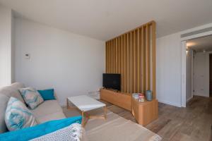 a living room with a couch and a tv at X-3 CALELLA DE PALAFRUGELL 6 PaX in Calella de Palafrugell