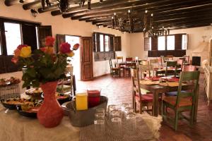 uma sala de jantar com uma mesa com comida e flores em Casona Quesada em Suesca