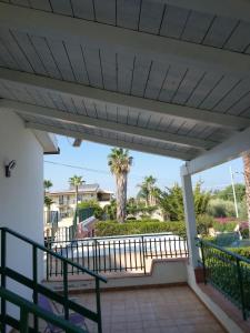 a balcony with a palm tree in the background at Casa vacanze a due passi dal mare in Avola