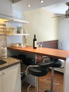 cocina con mesa de madera y 2 copas de vino en Monoambiente En Arturo Prat, en Montevideo