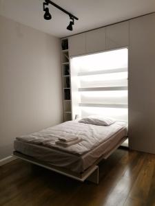 Nowoczesny Apartament z widokiem في وارسو: غرفة نوم بسرير ونافذة