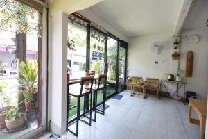 a room with large windows and a table and chairs at Banana Hostel Donmuang in Ban Don Muang (1)