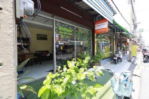 a store with plants in the window of a store at Banana Hostel Donmuang in Ban Don Muang