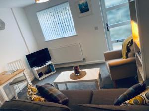 a living room with a couch and a table at Oliver's Yard in Helston