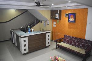 a kitchen with a sink and a couch in a room at Hotel Sai Vishwa in Shirdi