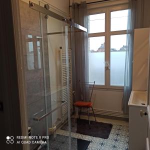 a shower in a room with a chair and a window at Chambre meublée in Saint-Aubin-lès-Elbeuf