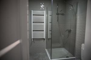 a bathroom with a shower with a glass door at Apartament Jana Pawła in Nowy Sącz +10 photos