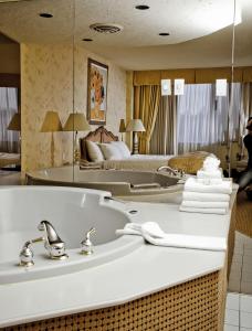 a bathroom with a sink and a bed at Travelodge by Wyndham Niagara Falls Fallsview in Niagara Falls