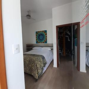 um quarto com uma cama e um quadro na parede em Suíte confortável em Florianópolis