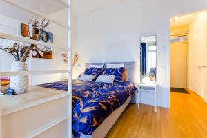 um quarto com uma cama com lençóis azuis e brancos em BenB Op de Trans, Arnhem op zijn best! em Arnhem
