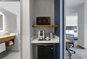 a room with a desk with a microwave and a bed at Holiday Inn Express & Suites - Collingwood in Collingwood