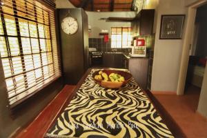 a kitchen with a bowl of fruit on a zebra print table at Casa Camacho in Marloth Park +22 photos