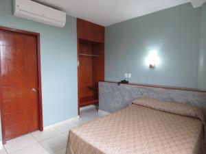 a bedroom with a bed and a wooden door at Hotel San Juan Periferico in Villahermosa +63 photos