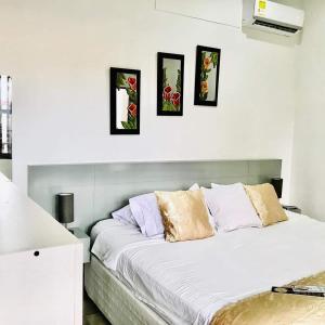 a white bed with four pictures on the wall at Santa Alejandría Hotel in Cartagena de Indias