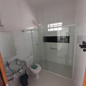 a bathroom with a shower and a toilet and a sink at Suíte confortável in Florianópolis