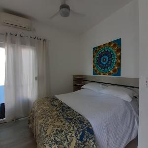 - une chambre avec un lit et une peinture murale dans l'établissement Suíte confortável, à Florianópolis