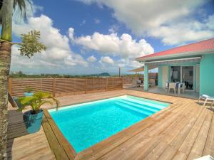 a swimming pool on a wooden deck with a house at SeaCove & SeaSide Villas, classées 4 étoiles in Les Trois-Îlets