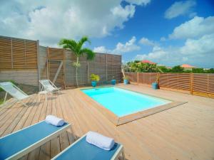 a swimming pool on a wooden deck with two lounge chairs at SeaCove & SeaSide Villas, classées 4 étoiles in Les Trois-Îlets