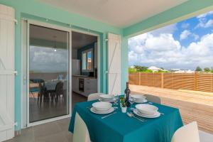 a dining room with a table with a blue table cloth at SeaCove & SeaSide Villas, classées 4 étoiles in Les Trois-Îlets