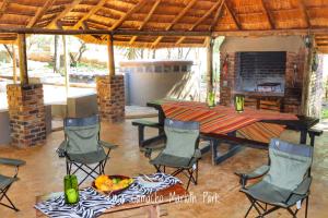 a patio with a table and chairs and a fireplace at Casa Camacho in Marloth Park
