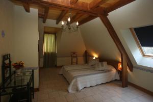 Saint-Amand-de-ColyにあるChambres d'Hôtes Larnaudieのベッドルーム1室(屋根裏部屋に大型ベッド1台付)