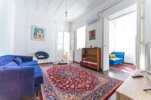 a living room with a blue couch and a rug at Town Apartment with panoramic seaview in Paphos