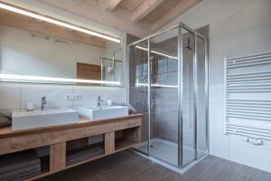 ペルティサウにあるAppartements Rosenhofのバスルーム(洗面台2台、ガラス張りのシャワー付)