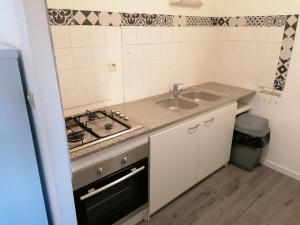 cocina pequeña con fregadero y fogones en Appartement meublé proche du futuroscope, en Poitiers