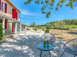 a patio with two chairs and drinks on a table at Cosy Holiday Home in Provence with Swimming Pool in Rasteau