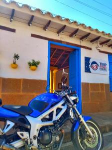 Una motocicleta azul estacionada frente a un edificio en Hostel Trip Monkey Barichara en Barichara