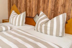 two beds with white and gray pillows on them at Land-Hotel Mühlengrund in Winterberg