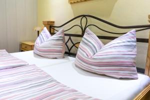 a pair of beds with striped pillows on them at Land-Hotel Mühlengrund in Winterberg