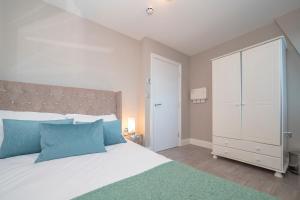a bedroom with a large white bed with blue pillows at MORDEN 1 BEDROOM 5 mins away from brighton seafront in Brighton & Hove