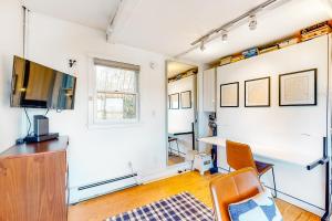 ein Wohnzimmer mit einem Schreibtisch und einem TV in der Unterkunft A Room With A View in Provincetown