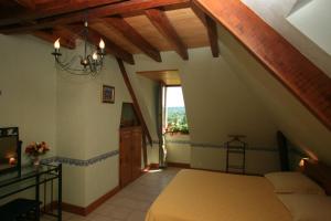 ein Schlafzimmer im Dachgeschoss mit einem Bett und einem Fenster in der Unterkunft Chambres d'Hôtes Larnaudie in Saint-Amand-de-Coly + 9 Fotos