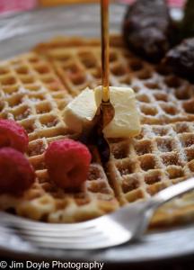 uma pessoa a comer um pedaço de manteiga num waffle em Mercersburg Inn em Mercersburg