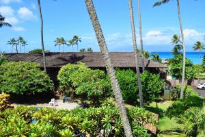 a resort with palm trees in front of a building at Napili Village Hotel in Kahana