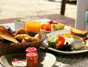 un tavolo con due piatti di cibo e un cesto di frutta di Villa Las Estrellas Tulum - located at the party zone a Tulum
