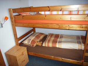 Etagenbett in einem Zimmer mit einem Etagenbett aus Holz in der Unterkunft Nordseeperle in Wangerland